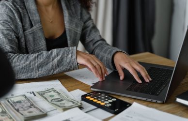 a woman in plaid blazer using her laptop