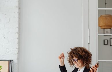 a woman in black blazer sitting in front of the table with laptop